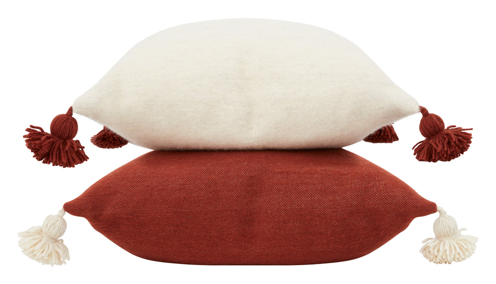 Bashir Floor Cushions, crafted from hand-spun, hand-dyed wool on traditional wooden looms in Morocco, feature a hidden zipper closure, a plush down and feather pillow insert, and charming pom-pom tassels in contrasting hues of ivory and Bordeaux.