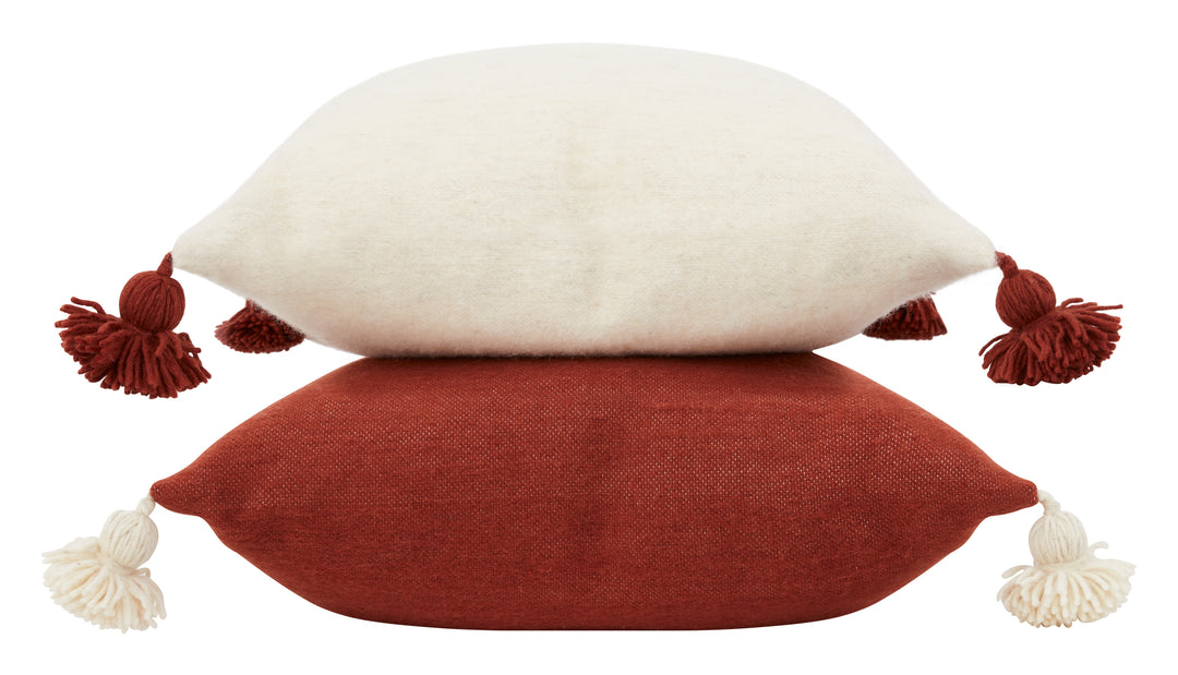 Bashir Floor Cushions, crafted from hand-spun, hand-dyed wool on traditional wooden looms in Morocco, feature a hidden zipper closure, a plush down and feather pillow insert, and charming pom-pom tassels in contrasting hues of ivory and Bordeaux.